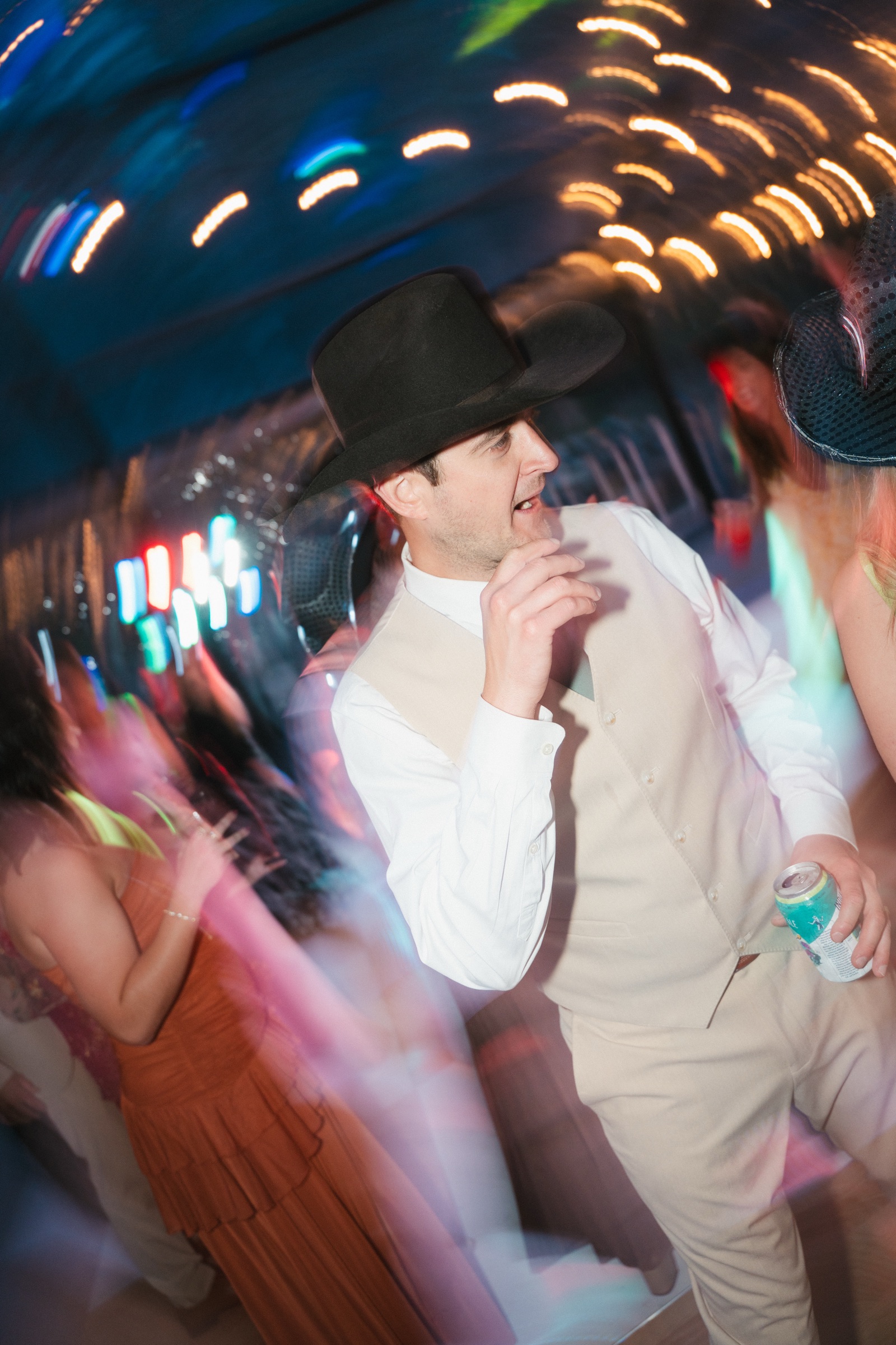 Guest in a black cowboy hat dancing, lights streaking behind him